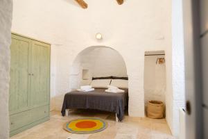 a bedroom with a bed in the middle of a room at Trullo Elce 11 in Putignano +39 photos