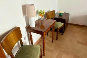a room with a wooden table with chairs and a lamp at B&B Antica Dimora in Pergola