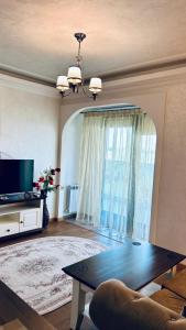 a living room with a table and a large window at Aparthotel Mirage Sunset - zona Hotel Rex in Mamaia