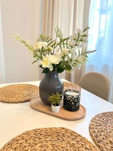 a black vase with white flowers on a table at Ferienwohnung Burgstraße in Manderscheid