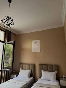 a bedroom with two beds and a picture on the wall at Guest House NIMA in Kutaisi +22 photos