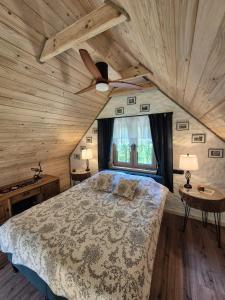 a bedroom with a bed and a ceiling fan at Woodland House 1 in Berezka