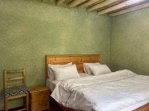a bedroom with a bed and a chair next to it at Brookfall resort khaplu in Khaplu