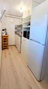cocina con nevera blanca y suelo de madera en LA Grâce d'Amboise, en Amboise