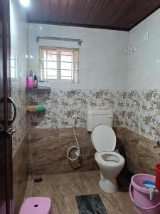 ein Badezimmer mit Toilette und Dusche in der Unterkunft Holiday cottage in Madikeri