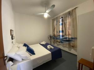 a bedroom with a bed with blue and white pillows at Vento a poppa in Porto Palo