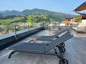 a couple of tables on a balcony with mountains at Pure Alpine Suites in Schladming