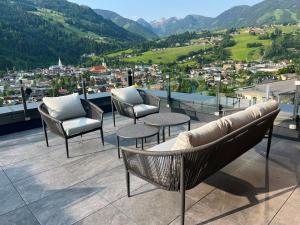 a balcony with chairs and tables and a view of a city at Pure Alpine Suites in Schladming +47 photos