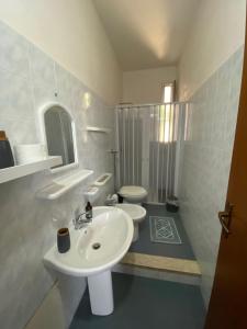 a white bathroom with a sink and a toilet at Vento a poppa in Porto Palo +37 photos