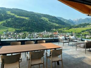a table and chairs on a balcony with mountains at Pure Alpine Suites in Schladming