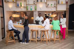 a group of people sitting at a bar at Illovo Hotel in Johannesburg +3 photos