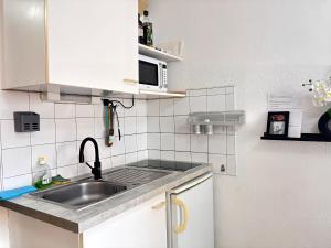 a small kitchen with a sink and a microwave at Les Logis de Paray Appartement 201 in Paray-le-Monial +2 photos