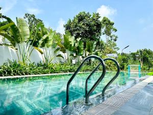 a swimming pool with blue water and plants at Tony Villa Homestay Ba Vì in Ba Vì