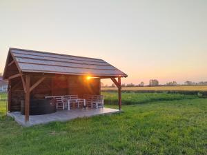 a gazebo with a grill in a field at Parittyaház in Homokmégy +4 photos