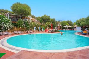 a pool at a resort with a person in the water at Borghetto di Badesi in Badesi