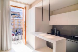 a kitchen with white cabinets and a view of a city at Virginia Madre Luxury Rooms in San Benedetto del Tronto +68 photos