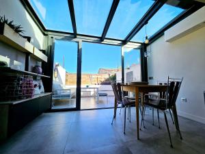 a dining room with a table and chairs and a large window at La Fourmilière - dans le Vieil Antibes in Antibes