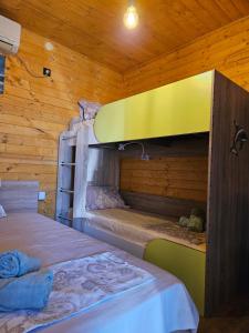 two bunk beds in a room with wooden walls at Бунгало HAKUNA MATATA, Къмпинг Созопол Еко, плаж Градина in Sozopol