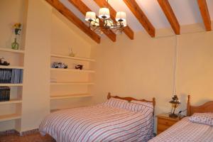 a bedroom with two beds and a ceiling at Cortijo de los Castellanos in Las Ventanas