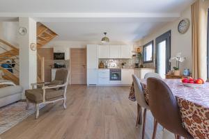 a kitchen and living room with a table and chairs at La Maison du Martrait - Proche de la plage in Graye-sur-Mer