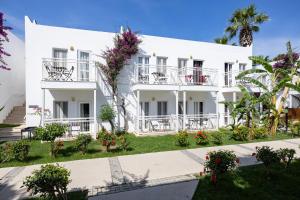 a large white building with balconies and flowers at Petunya Beach Resort in Ortakent
