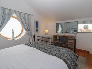 Un dormitorio con una cama y una ventana grande. en The Old Coach House at The Vicarage, en Hornsea