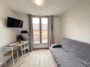 a living room with a couch and a table at T2 23m2 Confort calme Centre ville Paray app 408 in Paray-le-Monial