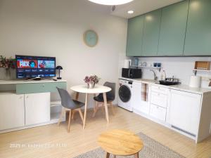 a kitchen with green cabinets and a table and chairs at Happy Inn Sweet Old Town Studio, Self check in, Parking in Vilnius