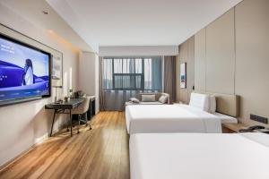 ein Hotelzimmer mit zwei Betten und einem Flachbildfernseher in der Unterkunft Atour Hotel Hangzhou Xiaoshan Peoples Square in Hangzhou