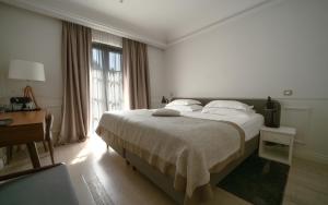 a bedroom with a bed and a desk and a window at Hotel Majestic in Budva