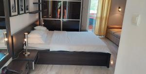 a bedroom with a large bed and a couch at Apartments Danilo Kažanegra in Sveti Stefan