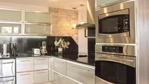 a kitchen with stainless steel appliances and white cabinets at Chefs Delight in San Juan