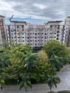 a large apartment building with trees in front of it at BRP Luxe Condo with Parking and Wifi in Davao City