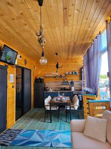 a living room with a table and a kitchen at Бунгало HAKUNA MATATA, Къмпинг Созопол Еко, плаж Градина in Sozopol