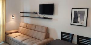 a living room with a couch and a flat screen tv at Apartments Danilo Kažanegra in Sveti Stefan