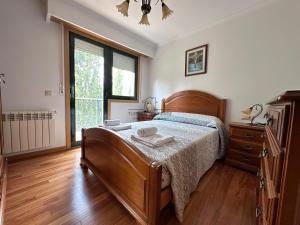 a bedroom with a bed and a dresser and a window at Parque Ávila in Ourense