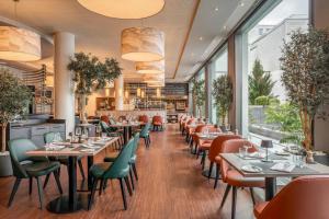 a restaurant with tables and chairs and windows at Courtyard by Marriott Munich City Center in Munich
