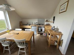 a kitchen with a large wooden table and chairs at By the Lighthouse in Vogar