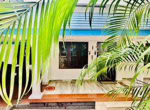 瓦尔卡拉Varkala Escape Resort的棕榈树屋的前门