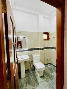 a bathroom with a white toilet and a sink at Bentota Upali Villa in Bentota +11 photos