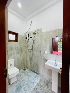 a bathroom with a toilet and a sink at Bentota Upali Villa in Bentota
