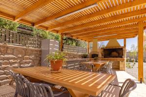 an outdoor patio with a wooden table and a fireplace at Arfna Villas in Afantou