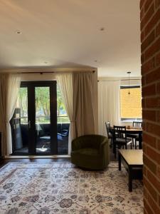 a living room with a green chair and a table at Renovated Charm - London Hideaway in London