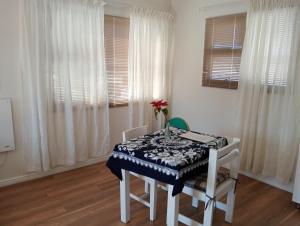 a dining room with a table and chairs and windows at The Wee Hoose in Strand