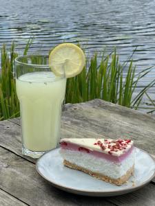 a slice of cake on a plate with a glass of milk at Glampingowy namiot nad Kanałem Augustowskim in Płaska