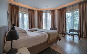 a bedroom with a large bed and windows at Hotel Majestic in Budva