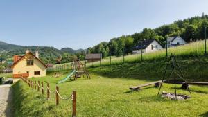 a park with a playground with a slide at Domek Wichrowy groń in Korbielów