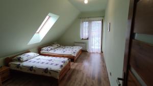 two beds in a small room with a window at Domek Wichrowy groń in Korbielów