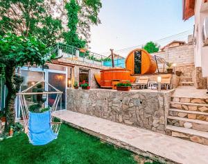a house with a hammock in a yard at Casa di Mare - Sauna & Jacuzzi in Balchik