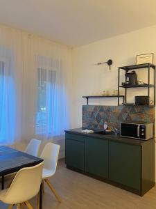 a kitchen with a counter and a table and chairs at GreBen Apartmanok in Eger